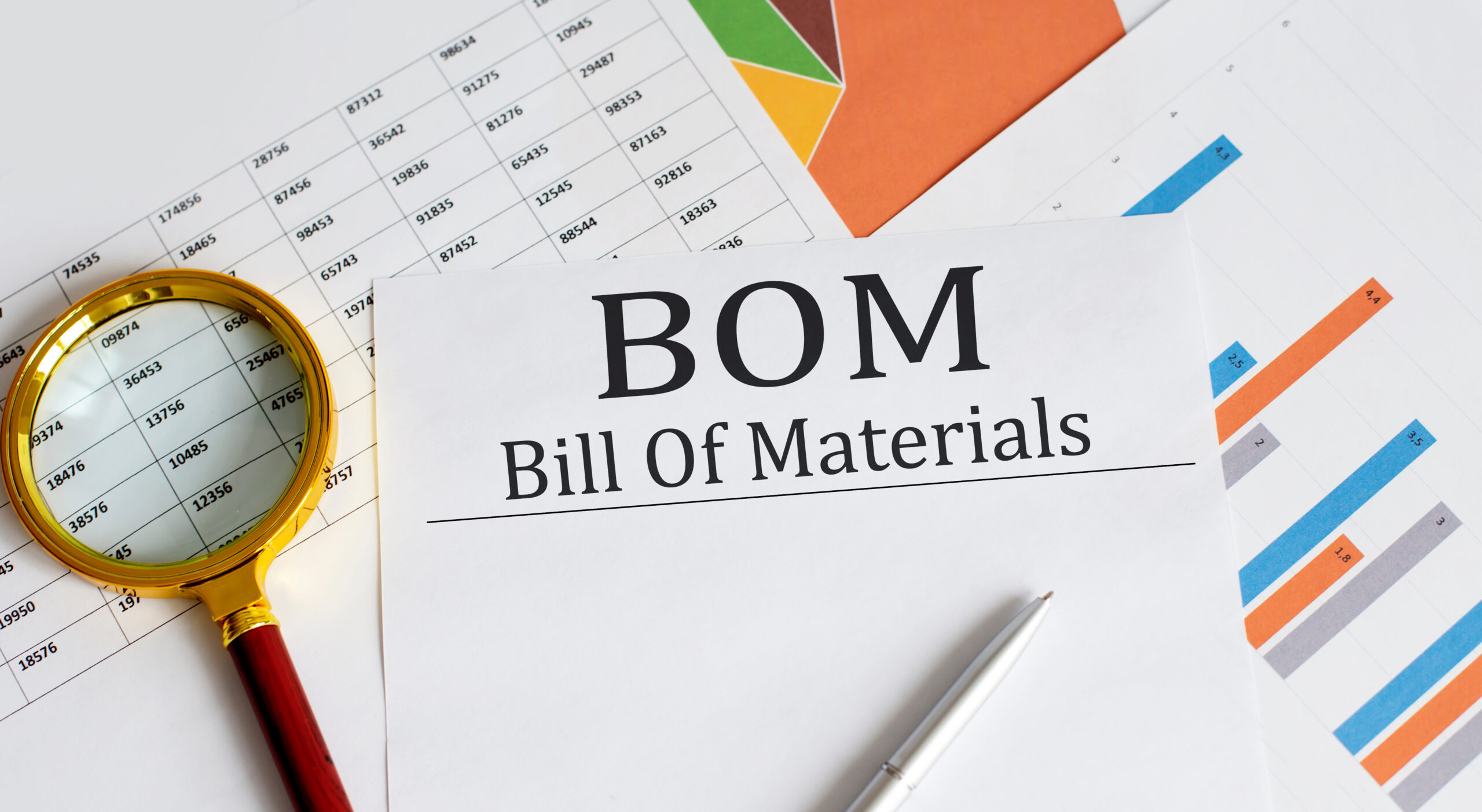 BOM - Bill Of Materials text with magnifying glass lens on the office desk table.